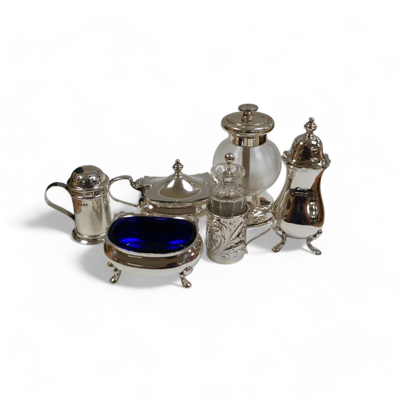 Six assorted silver condiments including a mounted ribbed glass pepper grinder and an Edwardian mounted glass cayenne pepper condiment, Condition - fair to good